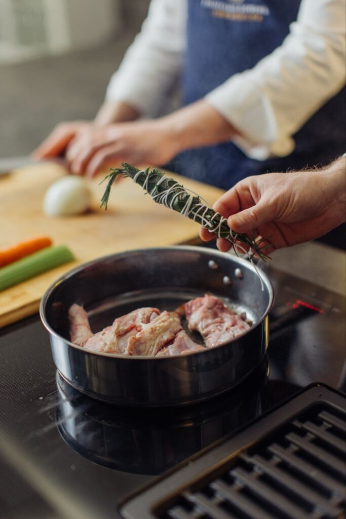two chef with a pan and a bouquet of herbs