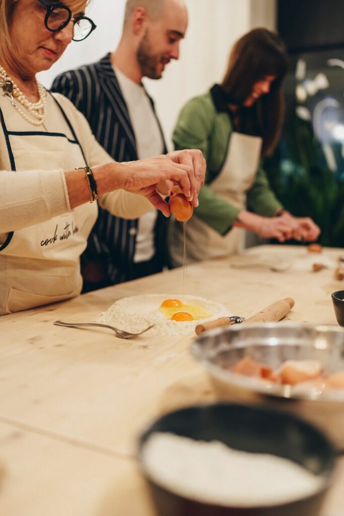 a woman doing a pasta class cracking a egg