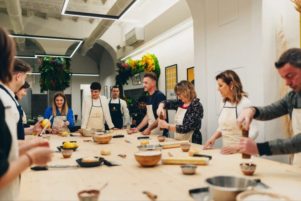 people joining a pasta making class in a big table full of ingredients
