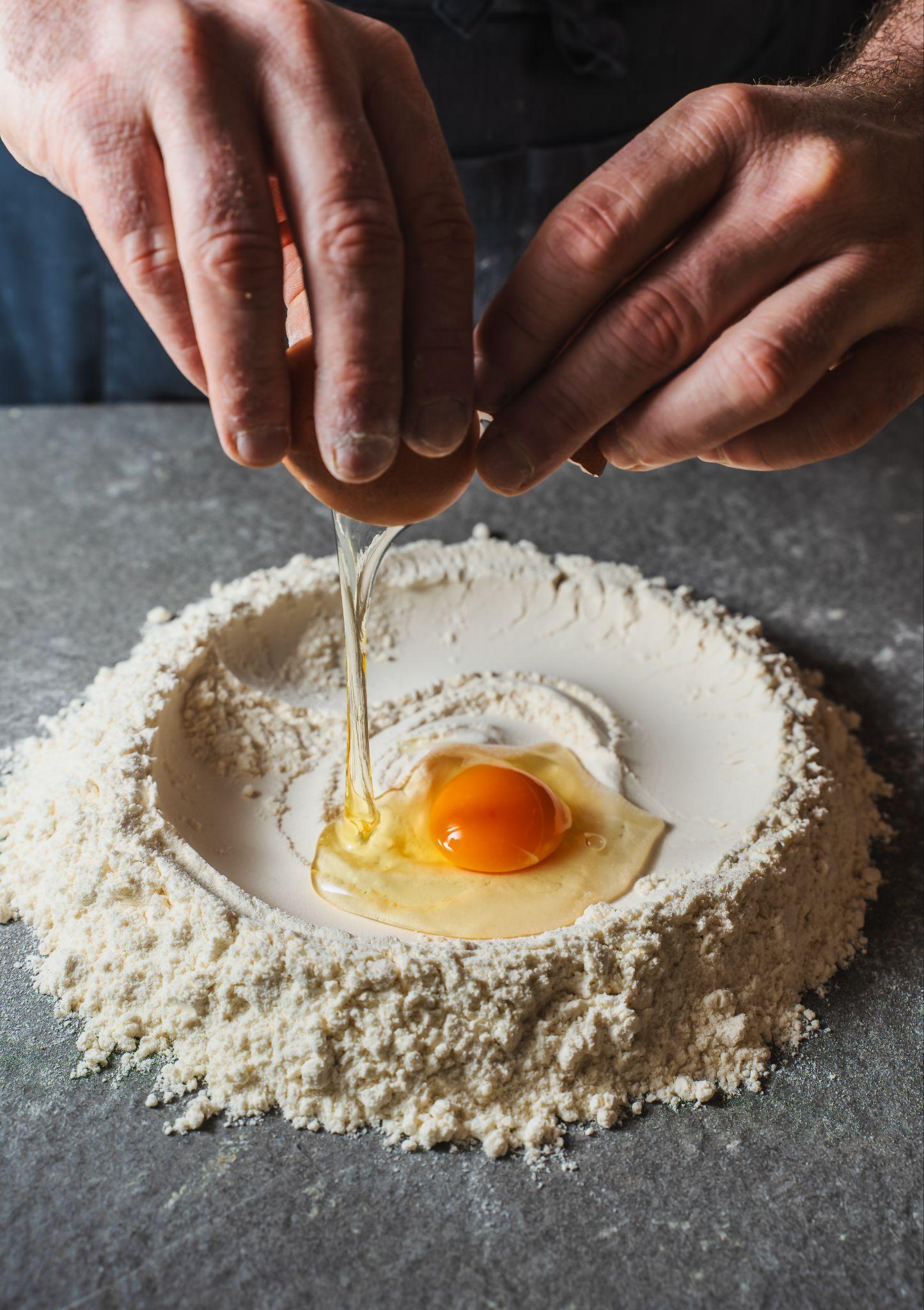Fresh egg pasta cut into ribbons on a floured surface